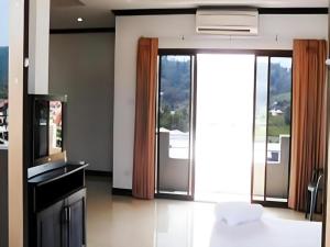 Il comprend une cuisine avec des portes coulissantes en verre et un balcon. dans l'établissement Kamala Phuyai Resort, à Kamala Beach