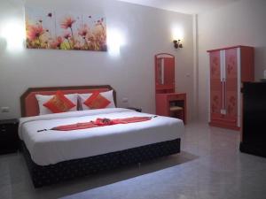 a bedroom with a bed and a painting on the wall at At night Airport Resort in Ban Bo Han