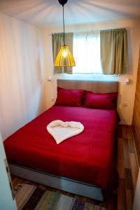 a red bed in a room with a red blanket at Seosko Domaćinstvo Protic , Prijedor , Veliko Palančište in Velika Palančište