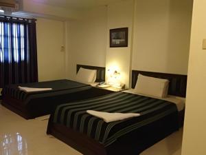 two beds in a hotel room with sidx sidx sidx sidx at Senesouk Hotel in Vientiane
