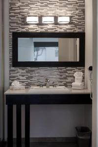 a bathroom with a sink and a mirror at Park Pointe Hotel in South San Francisco