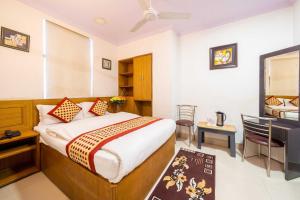 a hotel room with a bed and a desk and a television at Hotel Shiva in Jaipur