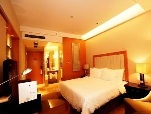 une chambre d'hôtel avec un lit et un canapé dans l'établissement Ramada Plaza by Wyndham Yangzhou Casa, à Yangzhou