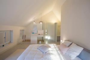 a white bedroom with a bed and a bathroom at B&B Opus35 in Montzen