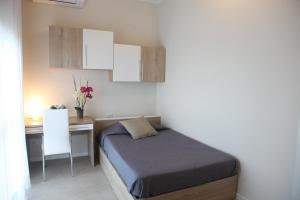 niewielka sypialnia z łóżkiem i biurkiem w obiekcie Residenze Italia w mieście Sesto San Giovanni