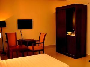 a bedroom with a bed and a table and chairs at Sai Sea City Hotel in Colombo