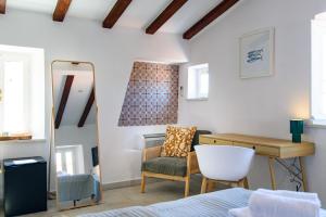 a bedroom with a bed and a chair and a desk at KALETA HOUSE by DuHomes in Dubrovnik