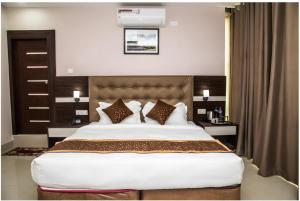 a bedroom with a large white bed with pillows at Hotel Gajur Palace in Itahari