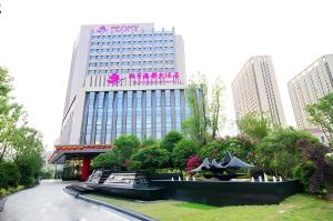厦门Peony Harbor City Hotel的顶部有标志的建筑物
