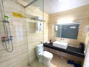 a bathroom with a toilet and a sink and a shower at Guo Bin Hotel in Danjiangkou +193 photos
