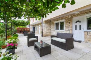a patio with chairs and a couch and a table at Apartments Nicole in Pula