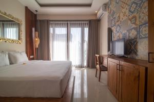 a bedroom with a large bed and a television in it at Villa Dewi 3 in Ubud +23 photos