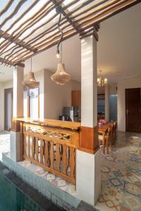 a kitchen and dining area of a house with a dining table at Villa Dewi 3 in Ubud