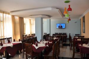 ein Esszimmer mit Tischen und Stühlen und einem Fernseher in der Unterkunft Lakemark Hotel and Tour Service Bahir Dar in Bahir Dar