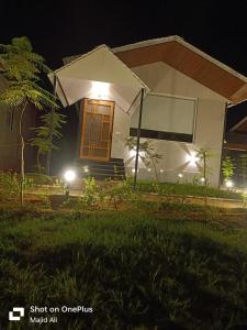 a house with lights in front of it at night at Rocopie Farm in Asthal Bohar
