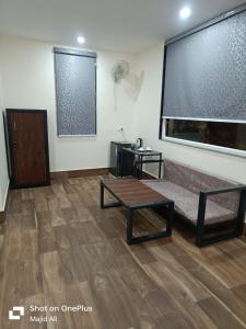 a living room with a coffee table and a large window at Rocopie Farm in Asthal Bohar +5 photos