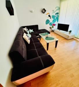 a living room with a black couch and a table at One Sunny Home in Sunny Beach in Sunny Beach +10 photos
