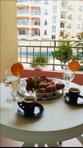 a table with a plate of food and cups of coffee at One Sunny Home in Sunny Beach in Sunny Beach