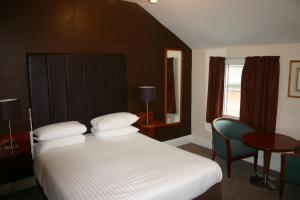 1 dormitorio con 1 cama, 1 mesa y 1 silla en The Vaults, en Shrewsbury