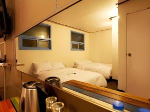 a hotel room with two beds and a mirror at W Mini Hotel in Seoul