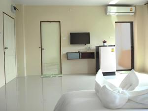 a living room with a white couch and a tv at Regent Room Hotel in Surat Thani