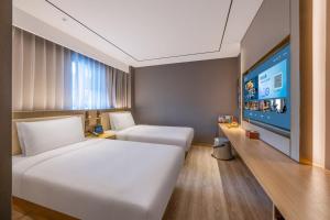A bed or beds in a room at Orange Hotel Beijing Tiananmen Dashilan
