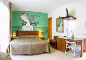 a bedroom with a bed with a painting on the wall at Hotel Regina in Lido di Camaiore +71 photos