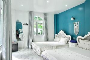 a bedroom with two beds and a blue wall at Cat Ba Santorini Homestay in Cat Ba +212 photos