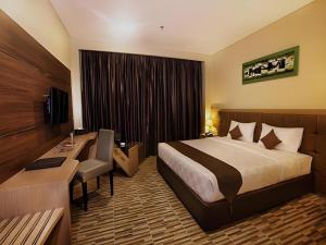 a hotel room with a bed and a desk at Asoka Luxury Hotel in Bandar Lampung