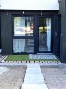 a black front door of a house with grass at SeaSide in Gdańsk