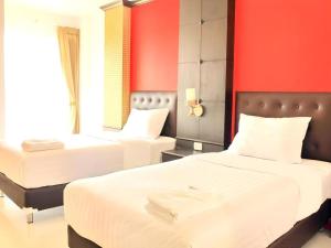 due letti in una stanza con pareti rosse di I-Yaris Boutique Resort a Khon Kaen