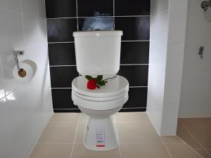 bagno con servizi igienici bianchi con un fiore rosso di I-Yaris Boutique Resort a Khon Kaen Altre 87 foto