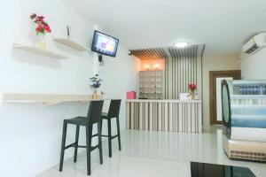 a room with a bar with two chairs and a tv at Cheaper Room in Surat Thani