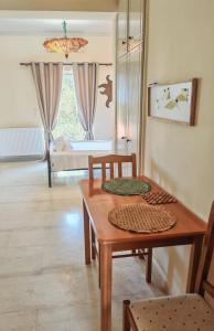a living room with a table and a bedroom at Gelsomino for two in Khelmáta +11 photos