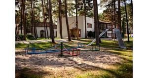 ein Spielplatz mit Rutsche in einem Park in der Unterkunft Chemar2 in Łeba