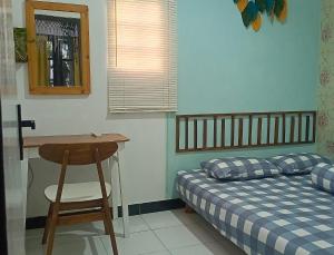 a bedroom with a bed and a table and a desk at Garser Bantul in Yogyakarta