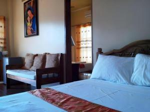 a bedroom with a bed and a couch and a chair at Anda de Boracay in Bohol Hotel in Anda +88 photos