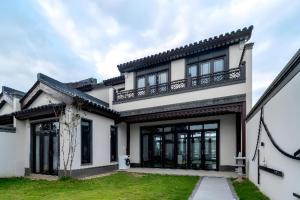 a white house with a balcony on top of it at Poltton International Service Apartment Fujian Changtai Mayangxi in Zhangzhou