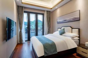 a bedroom with a large bed and a large window at Poltton International Service Apartment Fujian Changtai Mayangxi in Zhangzhou