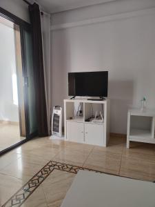 a living room with a flat screen tv on a white cabinet at Casa Marius in La Mata