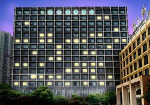 wysoki budynek z wieloma oknami w nocy w obiekcie City Comfort Inn Wuhan Huangpu w mieście Wuhan