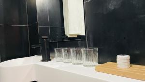 a bathroom sink with glasses sitting on a counter at The house where time is wasted under the road in Chongqing +32 photos