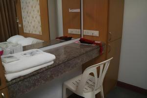 a bathroom with a counter with a mirror and a chair at Diamond Sweet Hotel in Bangkok +102 photos