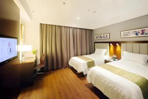 杭州Yitel Collection Hangzhou Binjiang Jiangnan Avenue Baolongcheng的一间有两张床和一台平板电视的酒店房间