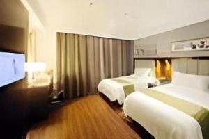 杭州Yitel Collection Hangzhou Binjiang Jiangnan Avenue Baolongcheng的一间有两张床和一台平板电视的酒店房间 更多37张照片