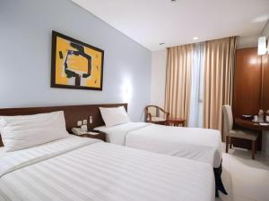 a hotel room with two beds and a desk at Sofyan Inn Tebet Family Friendly in Jakarta +210 photos