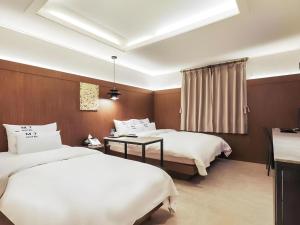 龙仁市Yongin(Giheung) M7 Hotel的有两张床和一张桌子的酒店房间