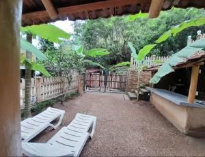 two white loungers sitting on the ground in a yard at Breezy Haven Ella in Ella