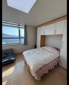a bedroom with a large bed and a large window at Hongdae Sinchon Skyview in Seoul +21 photos