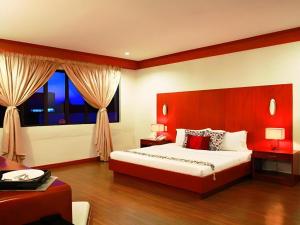 a bedroom with a large bed and a large window at Naga Land Hotel in Naga